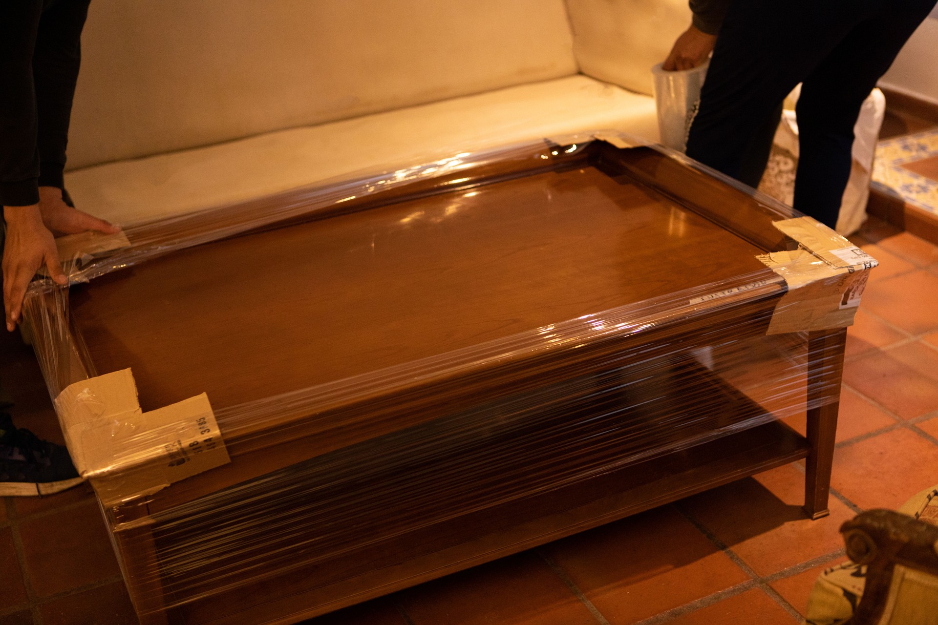 House moving process. Owner and moving staff packing, protecting and transporting furniture and movables to moving truck