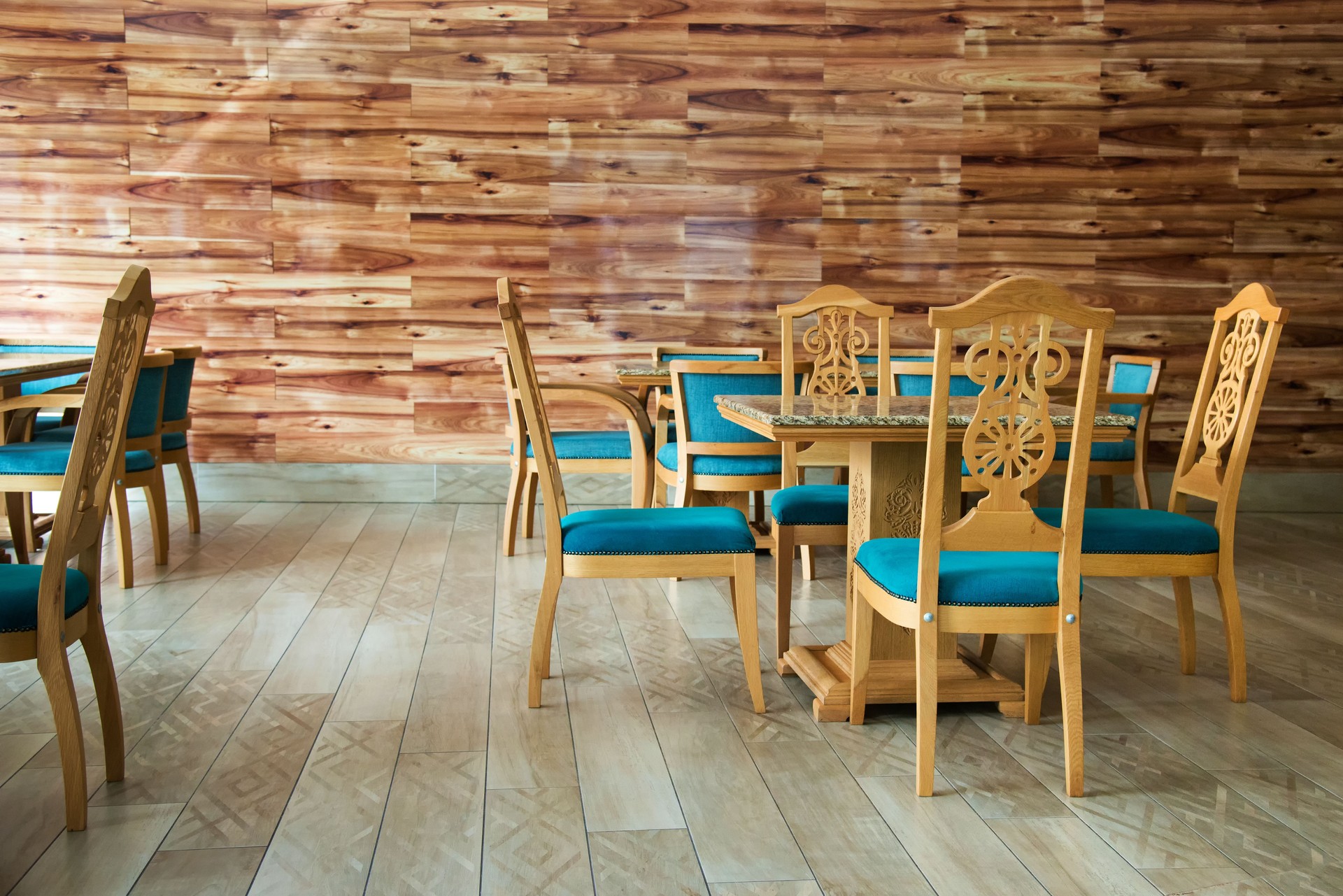 Restaurant interior with beautiful carved tables and chairs with blue fabric - selective focus